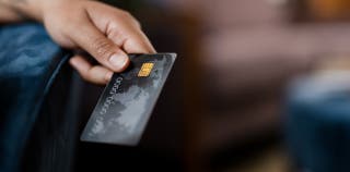 A person holding a black credit card. 